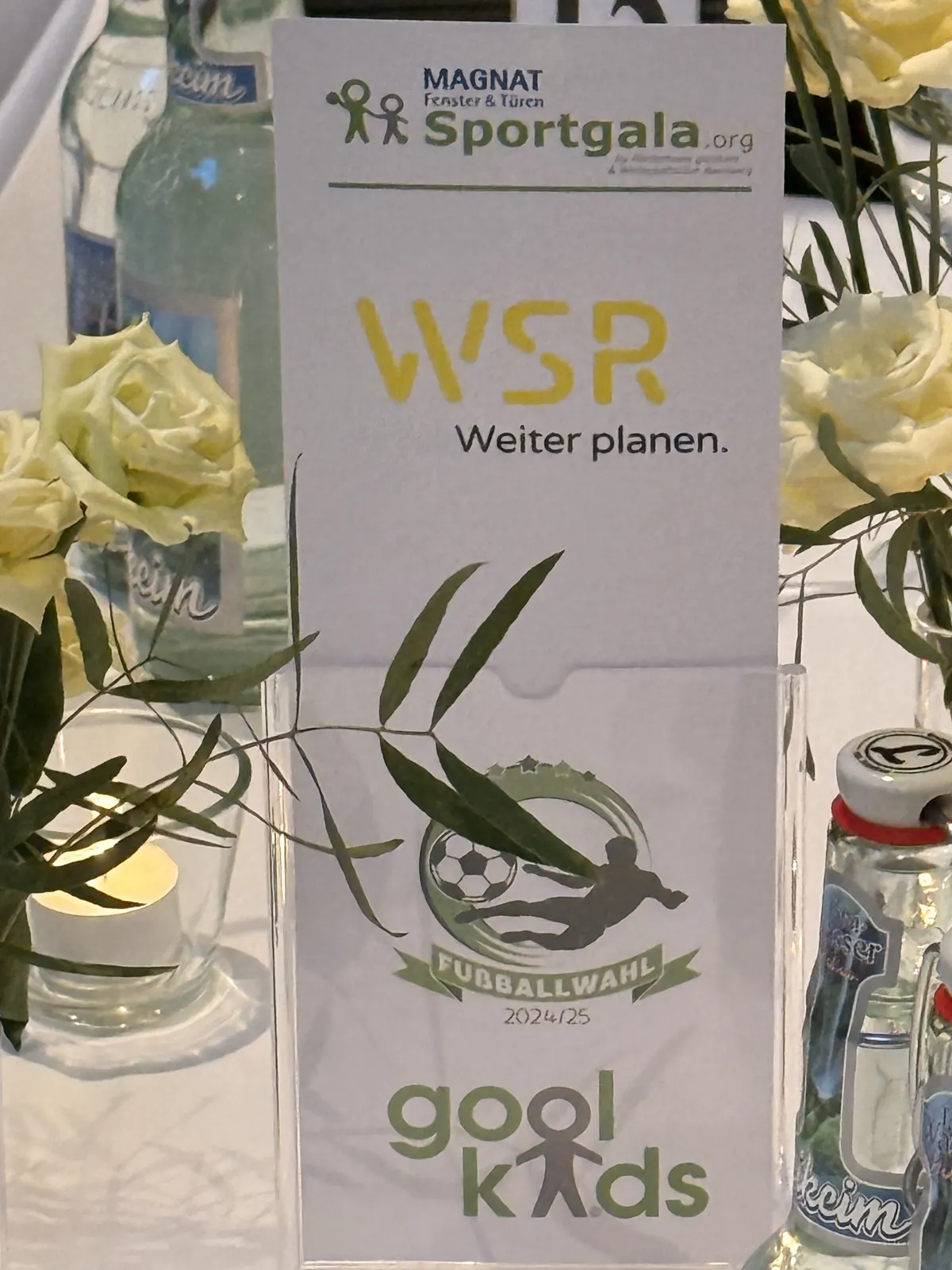 WSR-Tischkarte der Sportgala zwischen Blumen und Kerzen